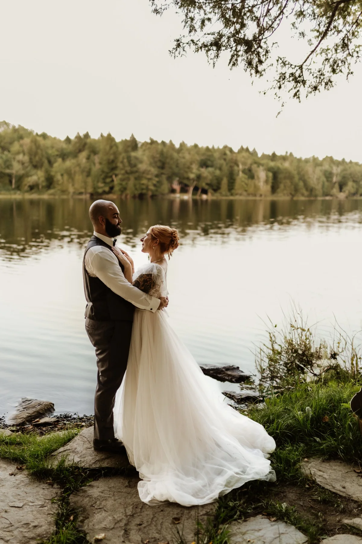 A newly married couple standing at the water's edge
